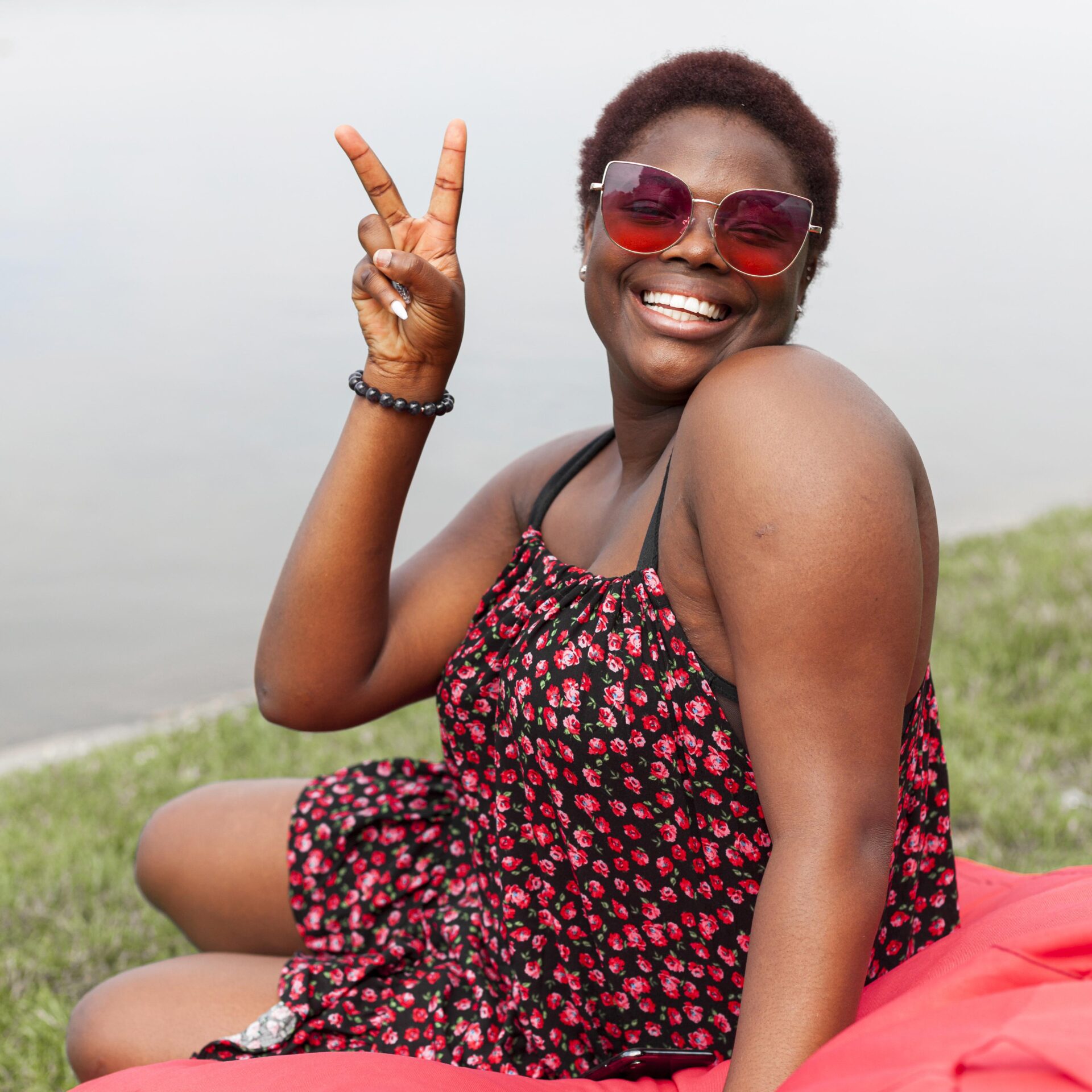 smiley-woman-posing-outdoors-bean-bag-making-peace-sign