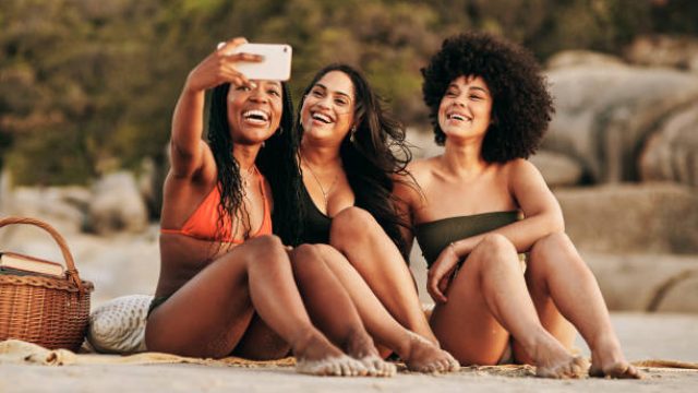 Shot of three friends taking a selfie while spending the day at the beach