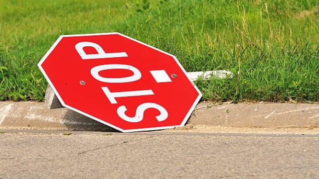 Stop sign fallen by the curb.